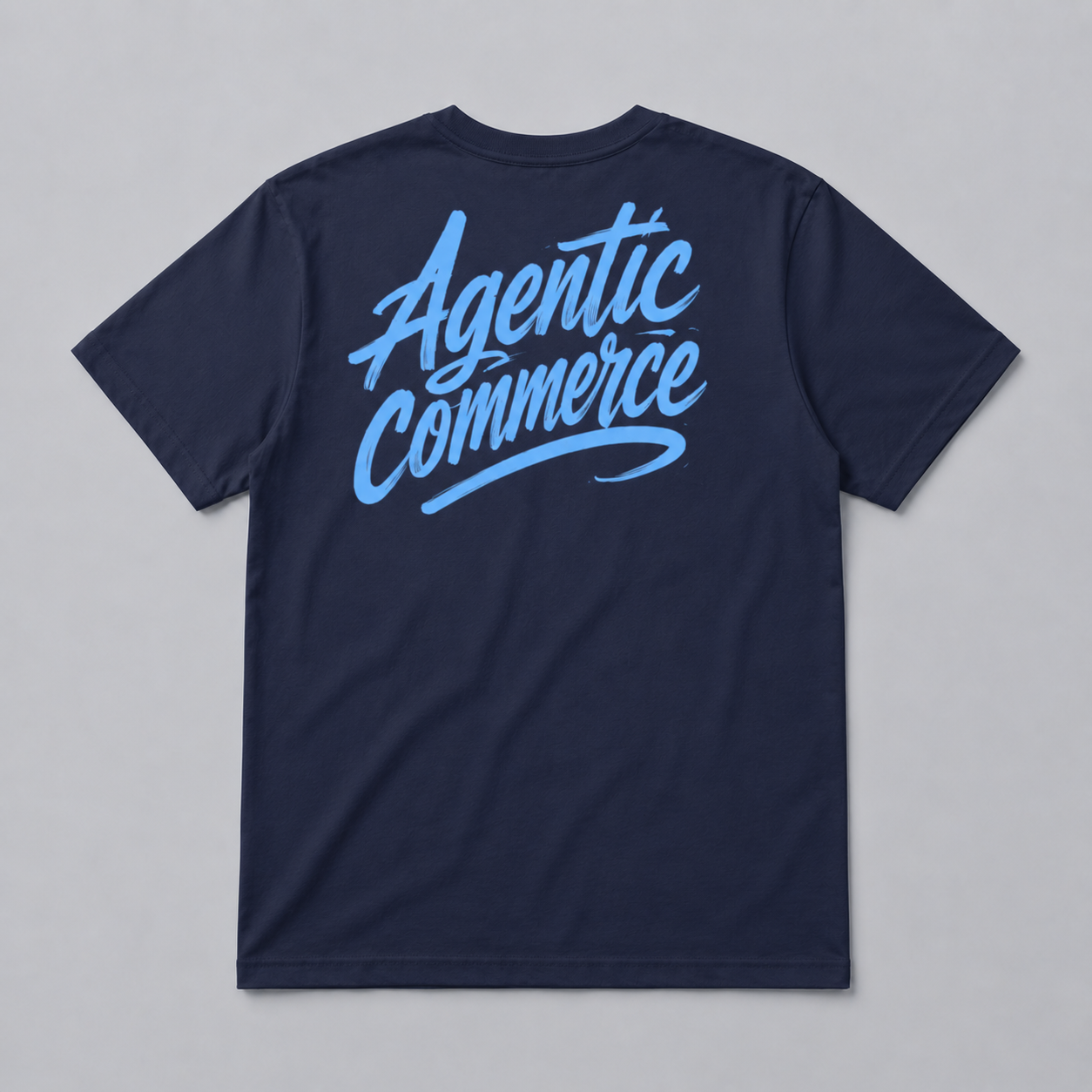 The Billboard blu is a navy blue, comfortable t-shirt crafted from soft cotton, featuring "Agentic Commerce" in large light blue cursive script across the back.